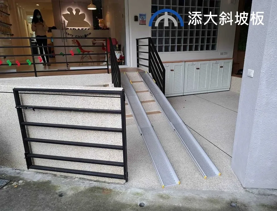 伸縮式輪椅斜坡板安裝於入口處 添大伸縮式鋁合金斜坡板安裝於店面階梯,提供無障礙通行動線。