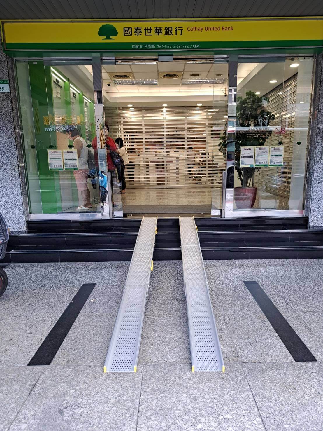 國泰世華銀行採用添大軌道可伸縮式斜坡板TT2-18-300，改善入口階梯障礙