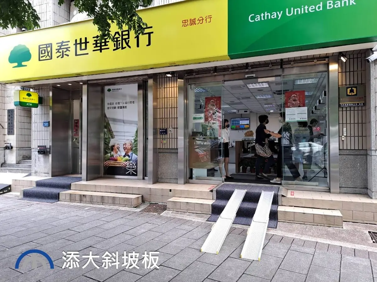 國泰世華銀行安裝輪椅斜坡板 國泰世華銀行門口裝設活動式伸縮斜坡板,提供輪椅無障礙通行